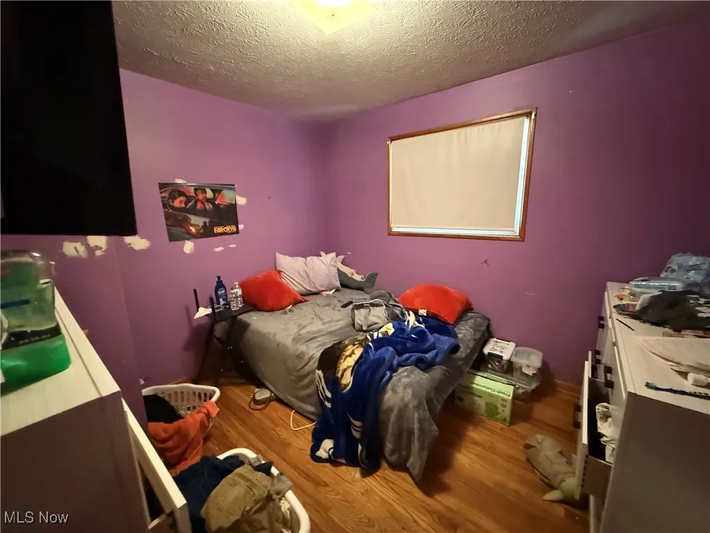 Bedroom featuring dark wood-type flooring and a textured ceiling