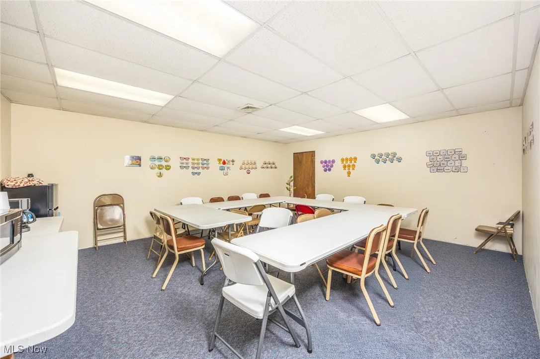 Meeting/dining space with carpet flooring and a drop ceiling