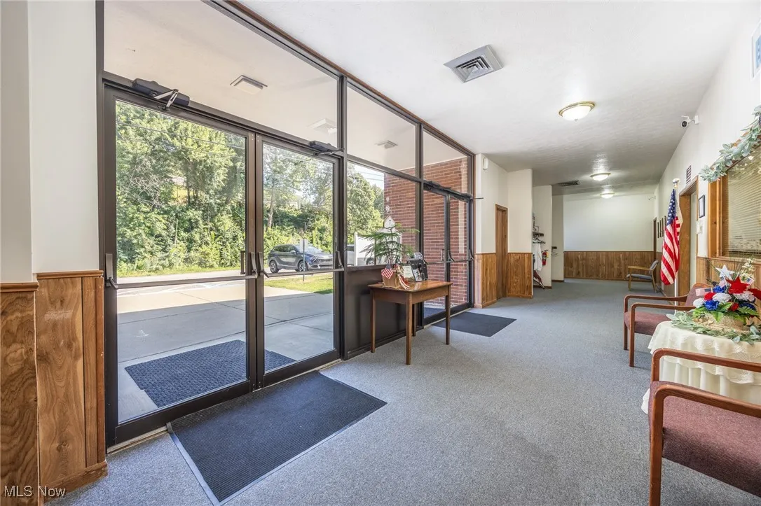 Common area with a wainscoted wall and wood walls
