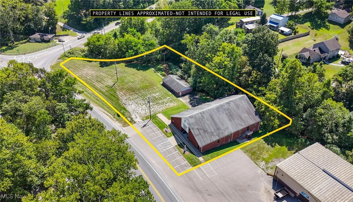 Aerial view of property and surrounding area with property boundaries highlighted and a tree filled landscape.