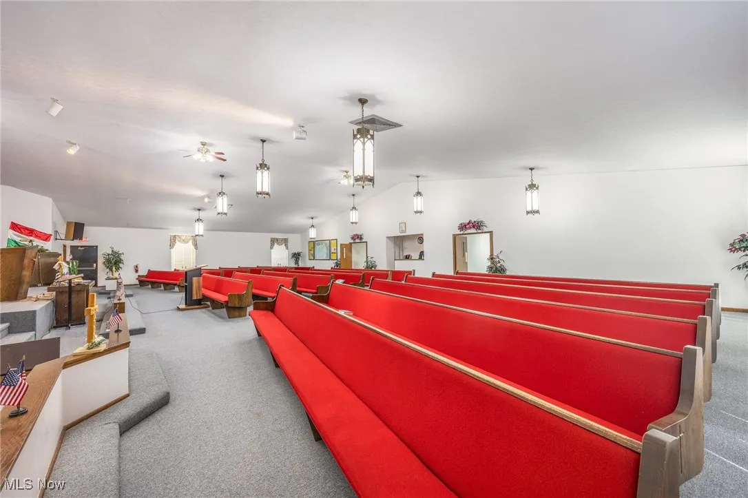 Misc room with vaulted ceiling and carpet flooring