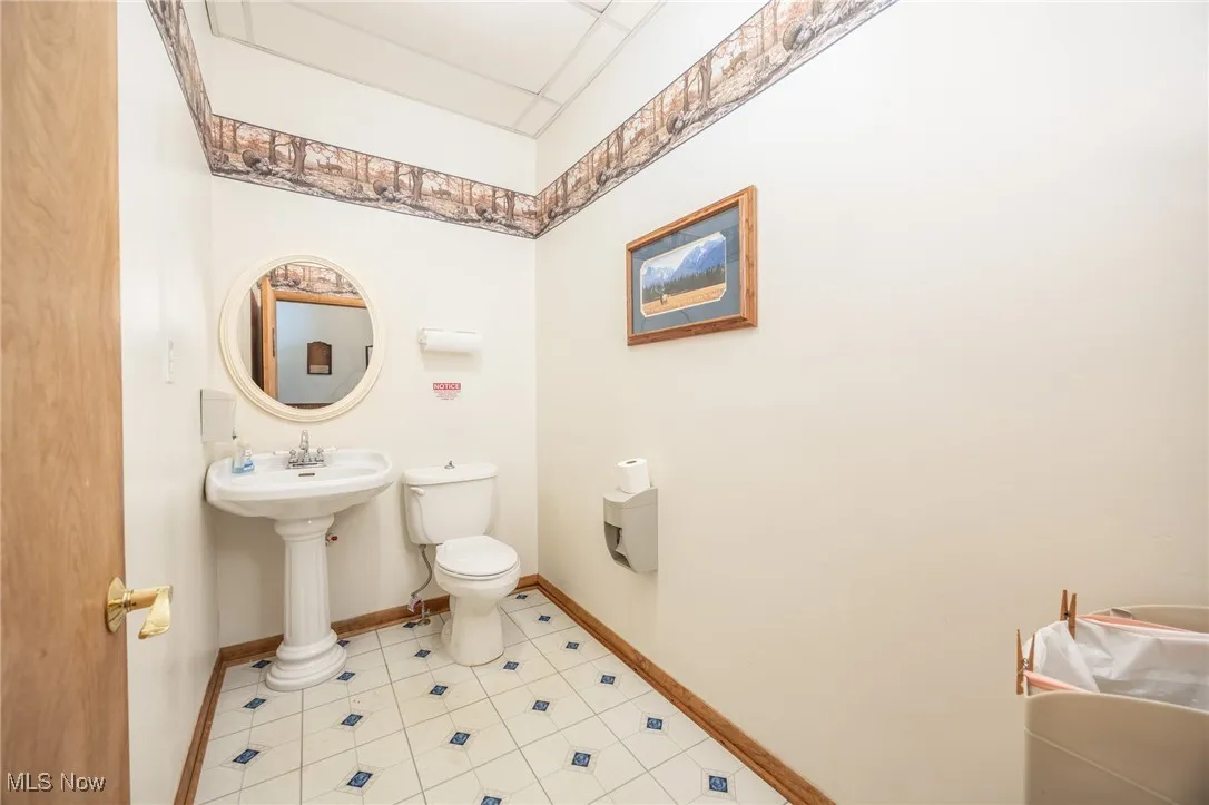 Half bathroom with light tile patterned floors and a paneled ceiling