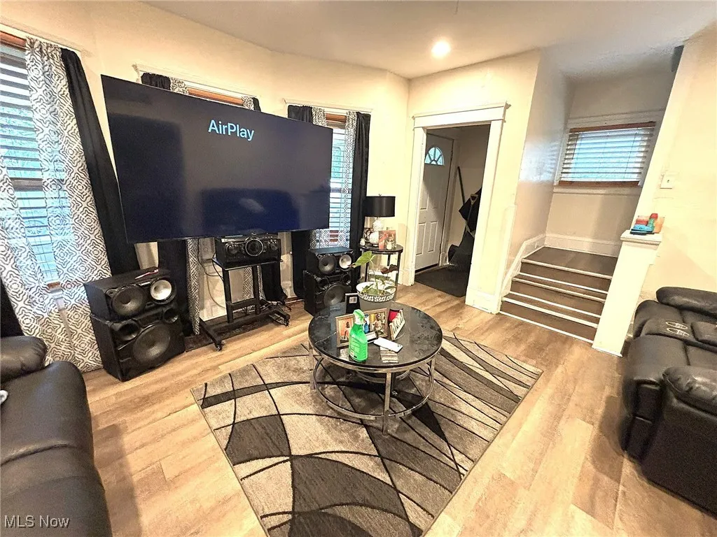 Living room featuring light wood-type flooring, plenty of natural light, recessed lighting, and stairway