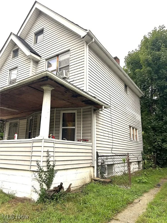 View of side of home with a porch and a chimney