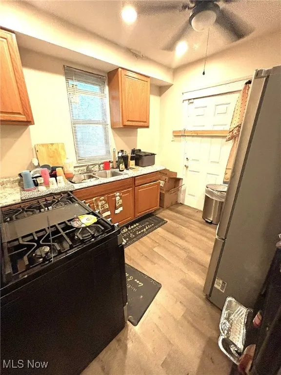 Kitchen featuring gas stove, light wood-style floors, freestanding refrigerator, recessed lighting, and ceiling fan