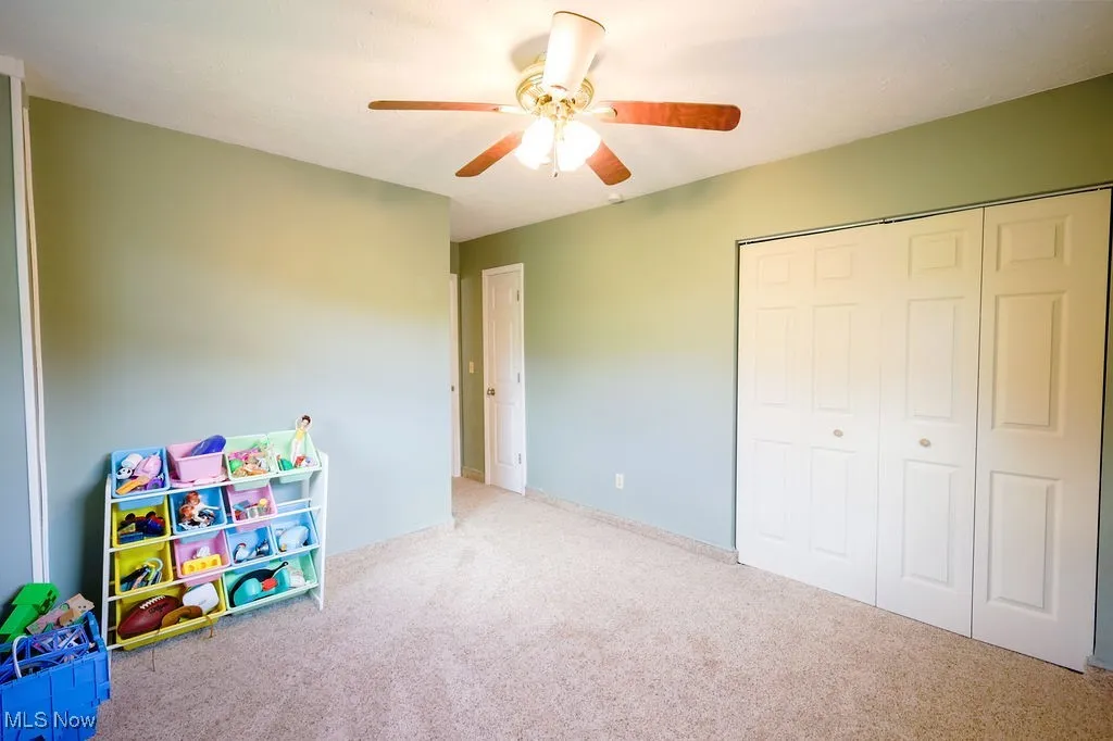 Recreation room with carpet floors and ceiling fan