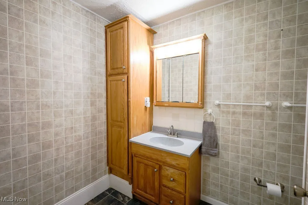 Bathroom with tile walls and vanity