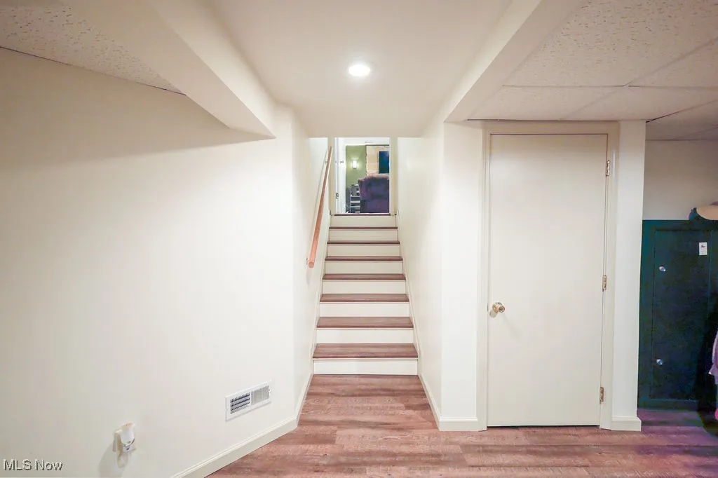 Stairs with wood finished floors and baseboards