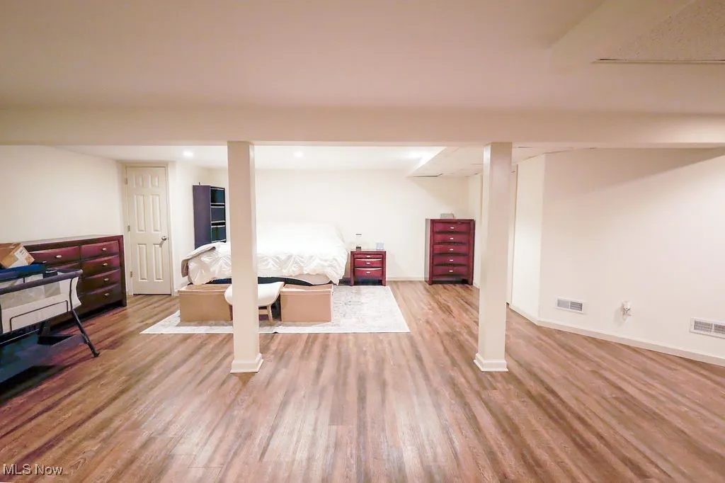Finished basement with wood finished floors and recessed lighting