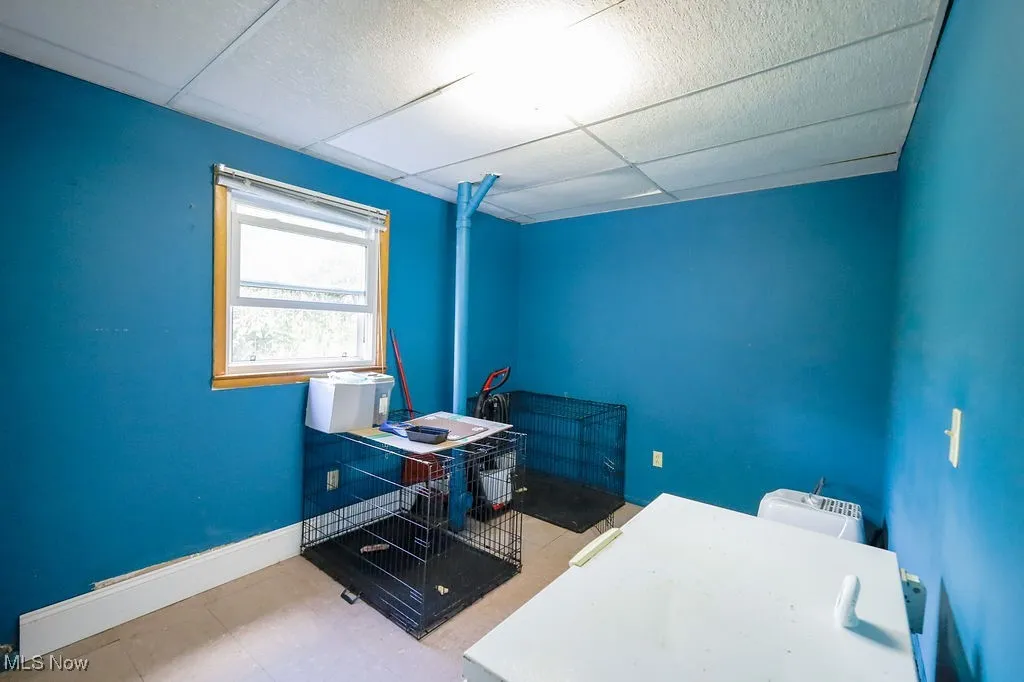 Office space featuring baseboards and a drop ceiling
