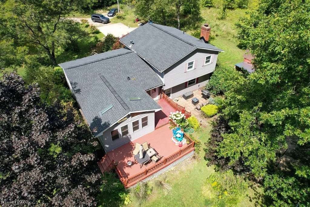Aerial view of property and surrounding area featuring a tree filled landscape