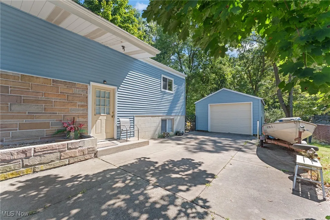 View of home's exterior with a detached garage, driveway, and an outbuilding