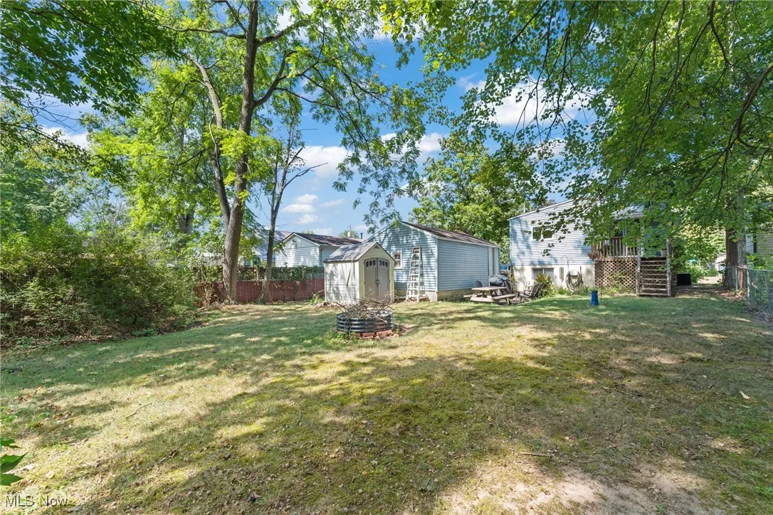 Fenced backyard featuring a shed and stairs
