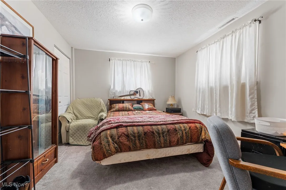 Bedroom with carpet floors and a textured ceiling