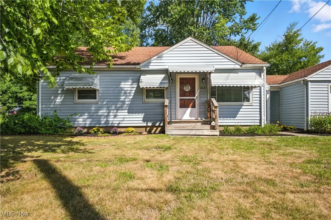 View of front of property with a front lawn and a shingled roof