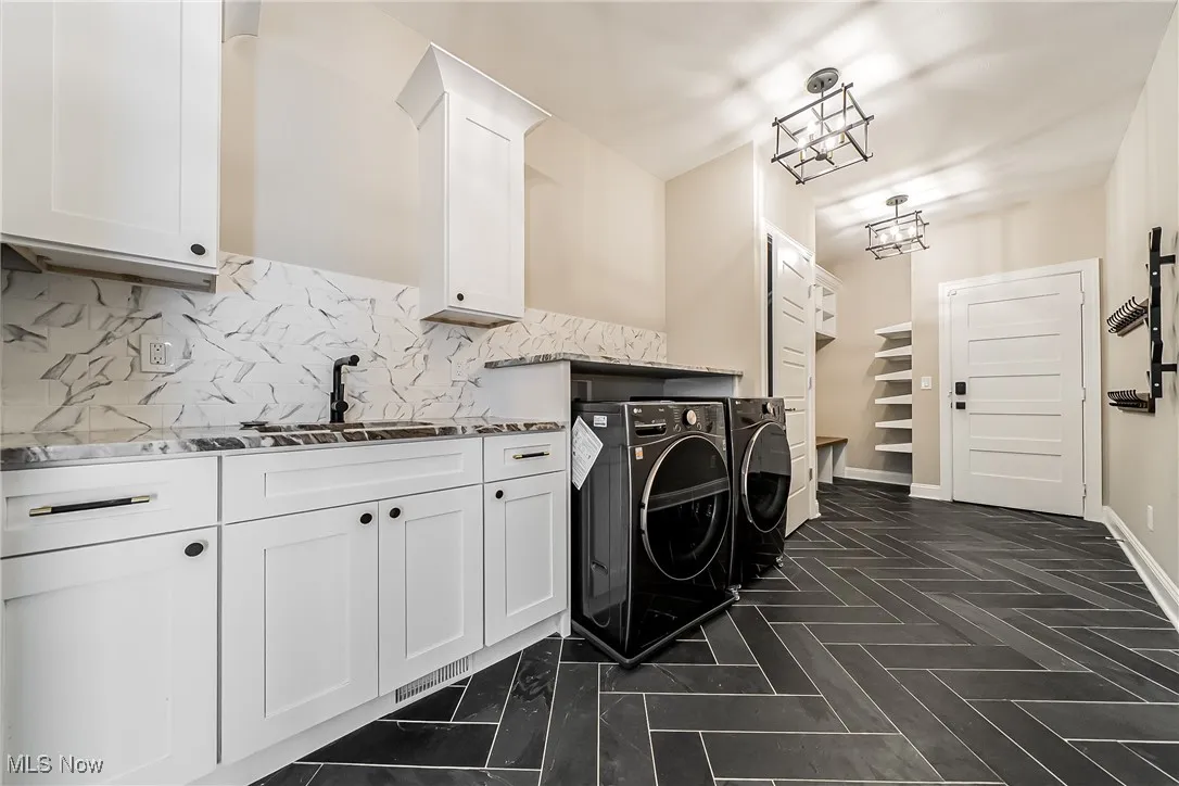 Washroom featuring separate washer and dryer and cabinet space