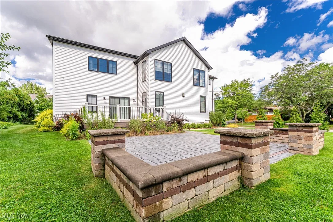 Rear view of property featuring a lawn and a patio