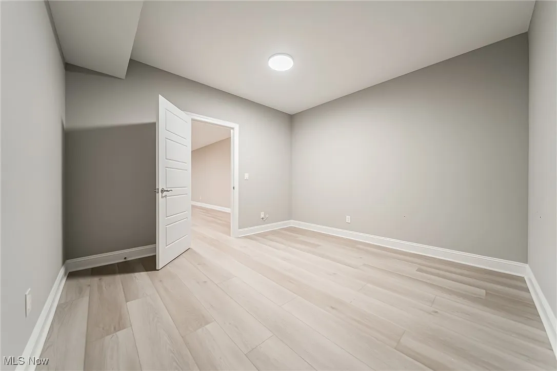 Unfurnished room featuring baseboards and light wood finished floors