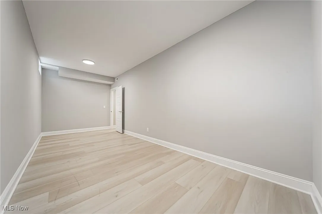 Empty room with light wood-style floors and baseboards