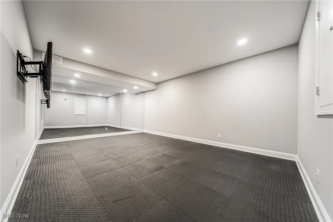 Empty room featuring recessed lighting and dark carpet