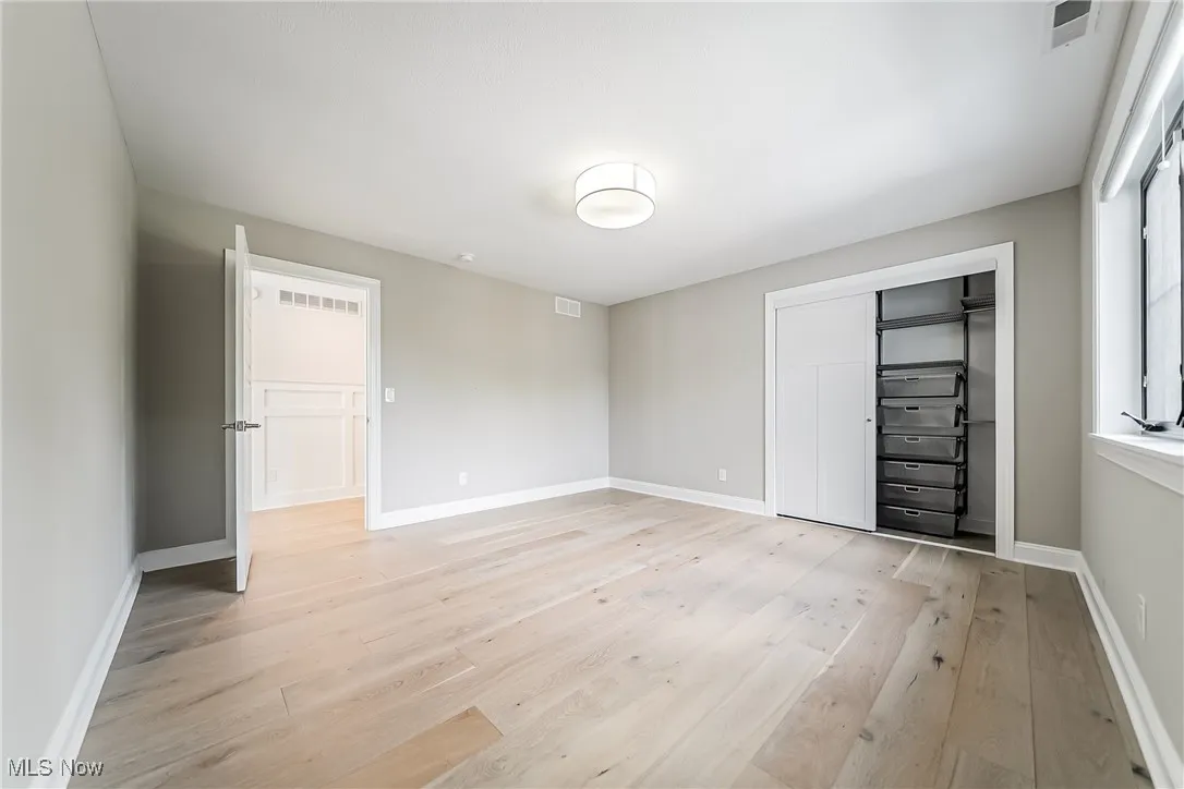 Unfurnished bedroom featuring light wood finished floors and a closet