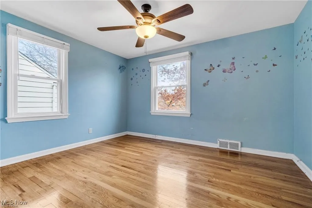 Empty room with light wood-type flooring and a ceiling fan