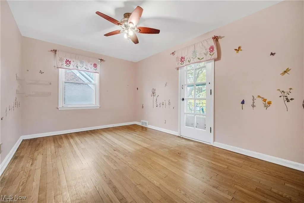 Spare room with light wood-style flooring, plenty of natural light, and ceiling fan