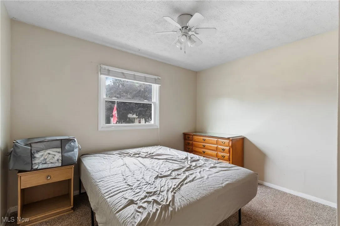Bedroom featuring carpet floors, a textured ceiling, and a ceiling fan