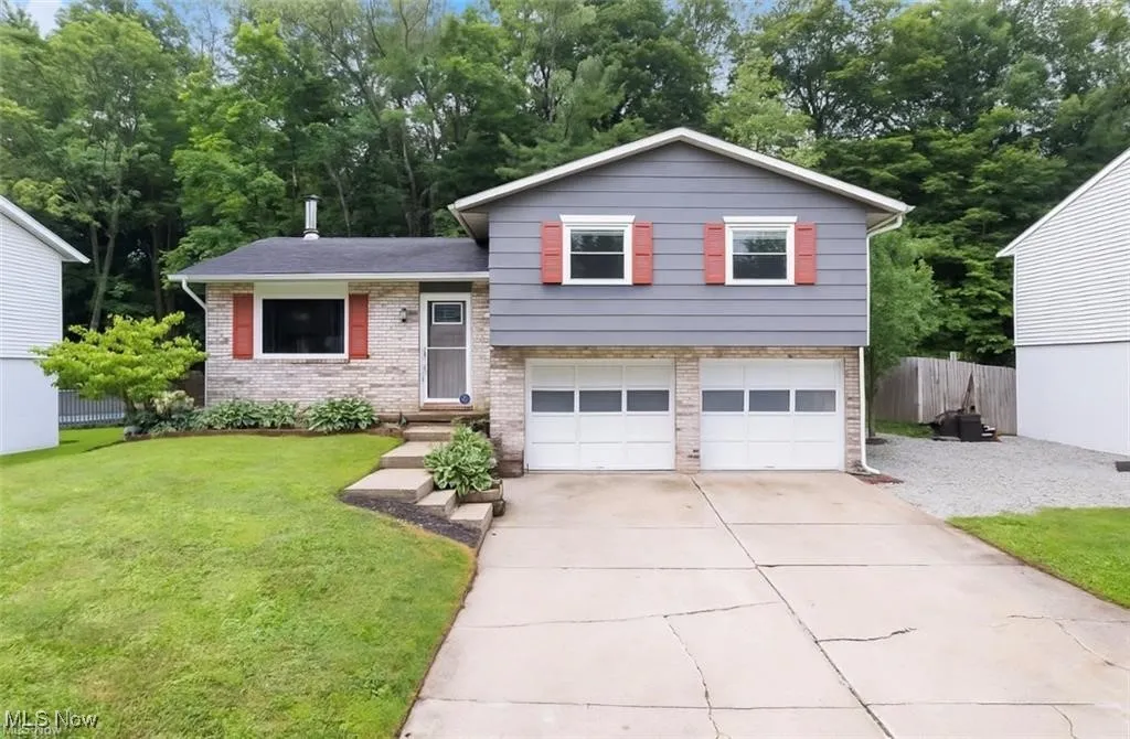 Tri-level home with brick siding, concrete driveway, and an attached garage