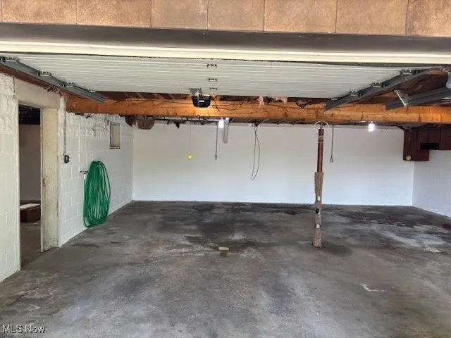 Garage featuring concrete block wall and a garage door opener