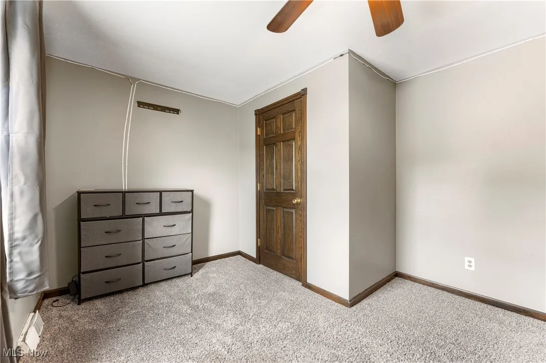 Unfurnished bedroom with carpet flooring and a ceiling fan