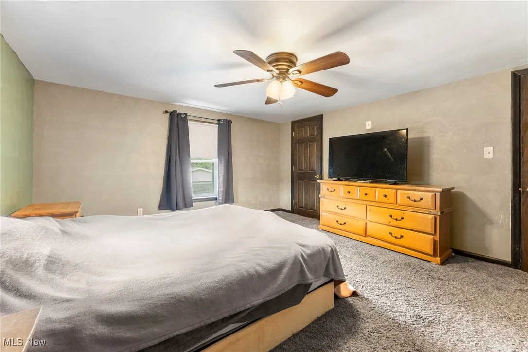 Carpeted bedroom with ceiling fan