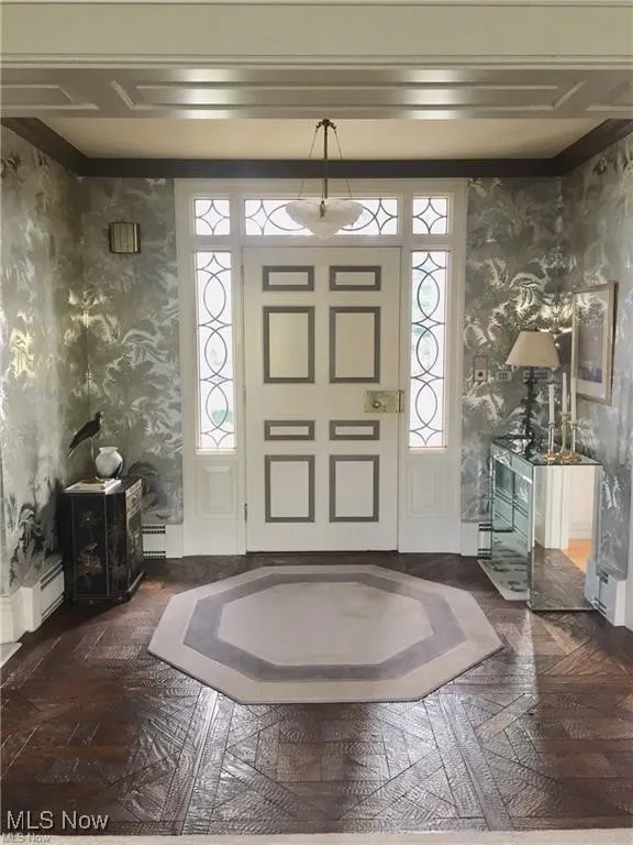 Entrance foyer featuring wallpapered walls and a baseboard heating unit