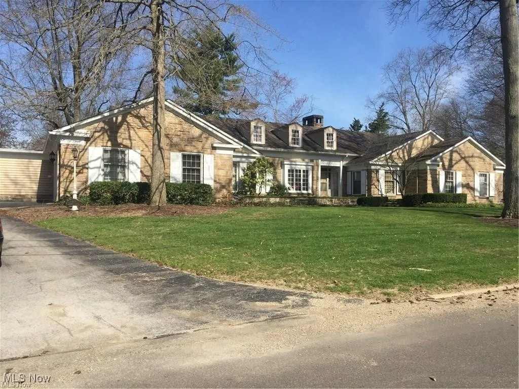 View of front of property with a front lawn and stone siding