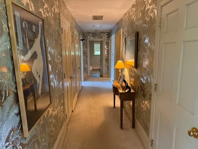 Corridor featuring wallpapered walls and baseboards