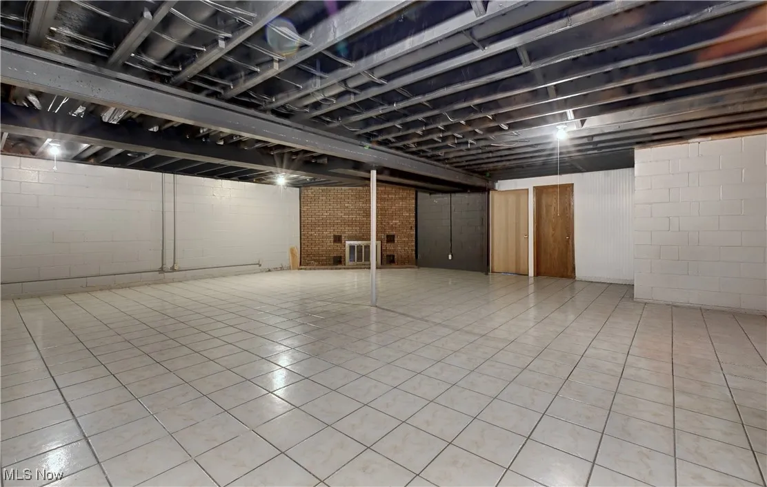 Finished below grade area with tile patterned flooring and a fireplace