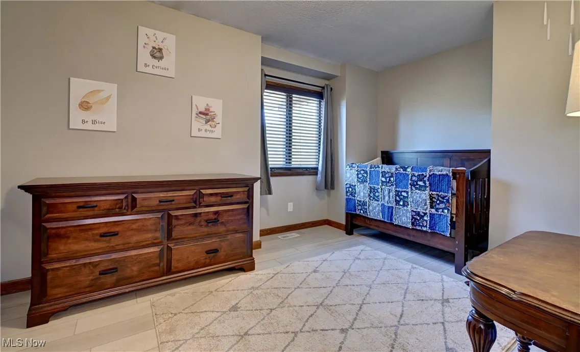 Bedroom with light wood finished floors and a textured ceiling