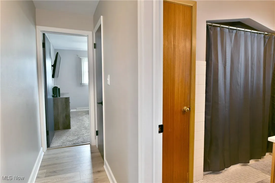 Hall featuring baseboards and light wood-type flooring