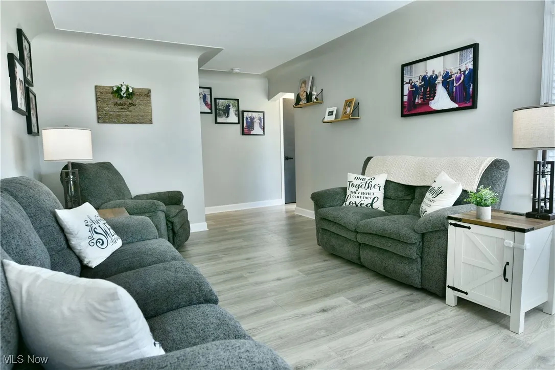 Living room with baseboards and light wood-style floors
