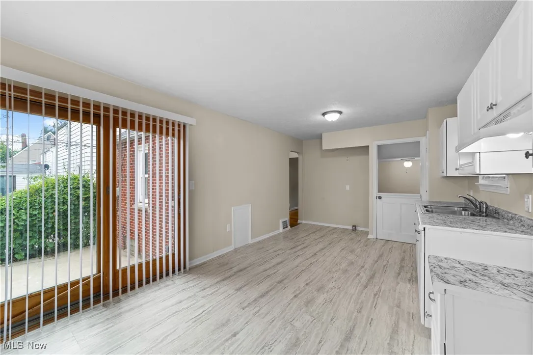 Wo enter this brand new kitchen with new kitchen cabinets, new sink, new lighting and new flooring.  This kitchen is spacious and leads to the outside fenced in yard.
