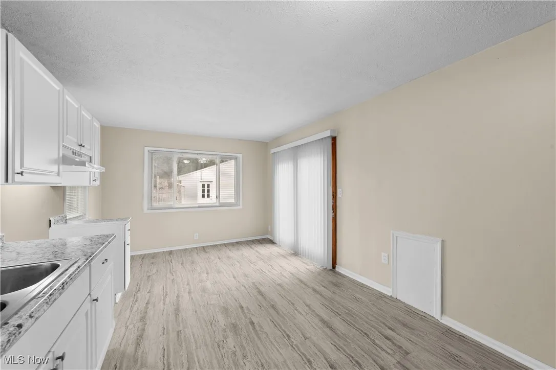 View shows the natural light of the kitchen and the doors that lead out to the fenced in yard