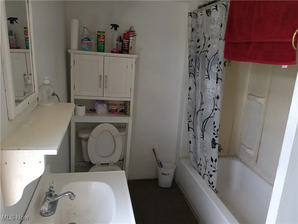 Full bath featuring shower / bath combo with shower curtain and vanity