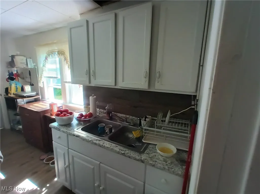 Kitchen with light countertops, white cabinets, and dark wood finished floors