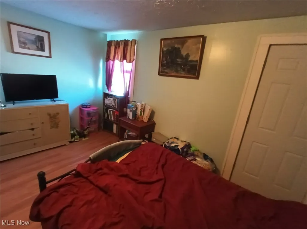 Bedroom featuring wood finished floors and a textured ceiling