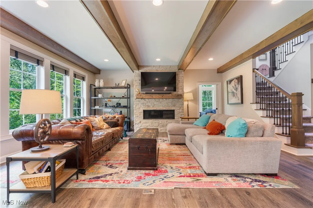 The great room has a lovely electric fireplace feature wall and beamed ceiling.