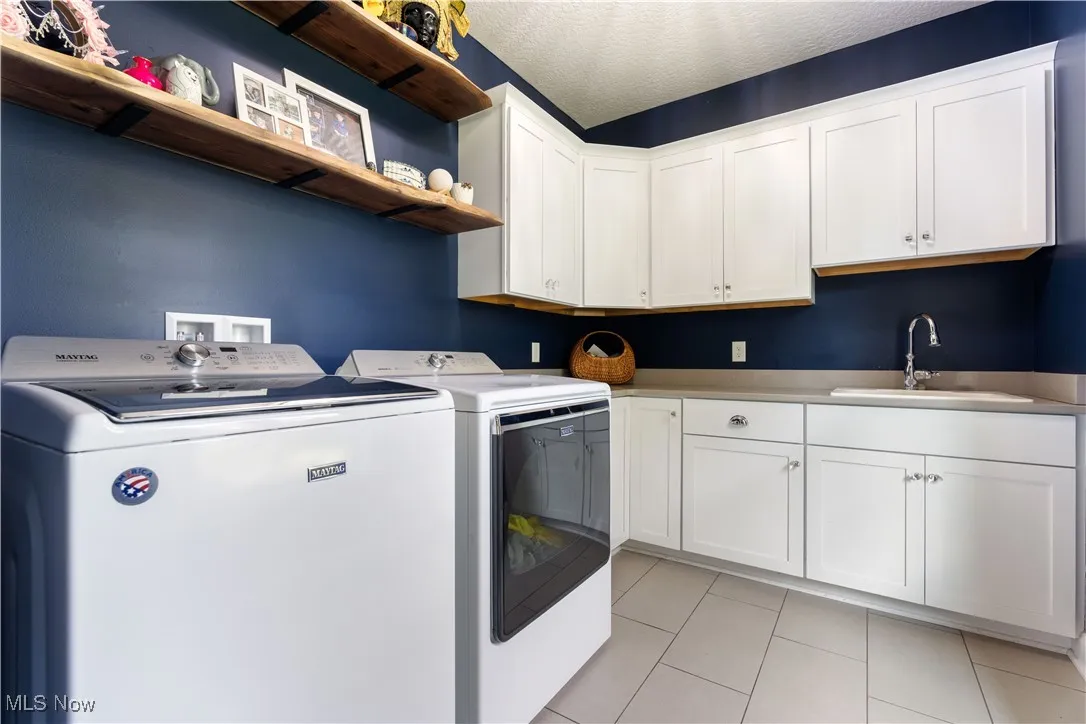 Fabulous first floor laundry room with cabinets and a sink.  Washer & dryer convey with the home.