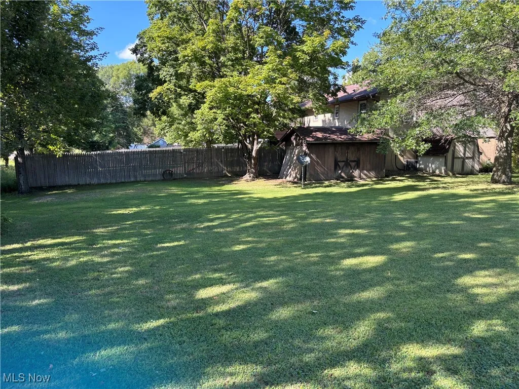 another view of the side yard included in the sale...totaling .55 acres with 2 sheds/outbuildings