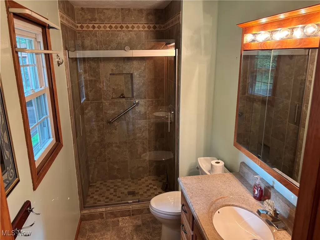 Master/ensuite Bathroom featuring vanity and a shower stall, and ample storage