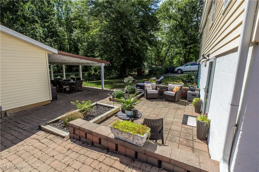 View of patio / terrace featuring an outdoor hangout area, outdoor dining space, and view of wooded area
