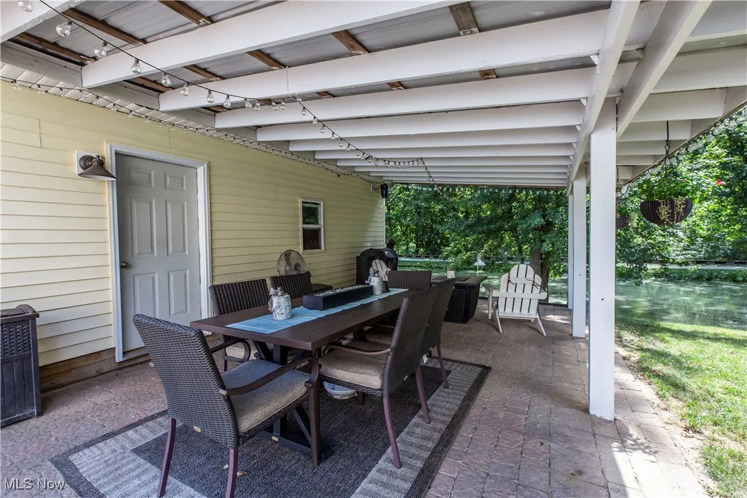 View of patio with outdoor dining area and a grill